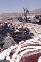 Image du Maroc Professionnelle de  Quelques ouvriers s'activent à réparer les filets de pêche sur un des quais au port d'Agadir, ville située au sud du Maroc, Vendredi 23 Août 2002. (Photo / Abdeljalil Bounhar)

